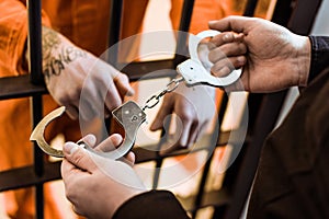 cropped image of prison officer wearing handcuffs