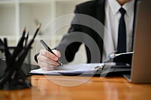 Cropped image of a professional male lawyer writing a notice letter at his desk