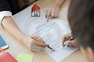 Cropped image of real estate agent assisting client to sign cont