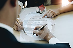 Cropped image of real estate agent assisting client to sign cont