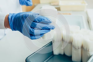 cropped image of scientist in latex gloves putting paper with seeds in modern