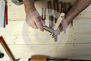 Cropped image of senior carpenter measuring wood in workshop