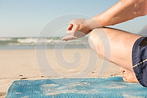 Cropped image of senior man meditating at beach