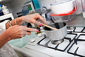 Cropped image of senior woman cooking at kitchen counter