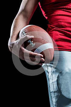 Cropped image of sportsman holding American football