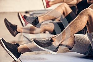 cropped image of sportsmen doing sit ups together