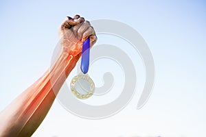 Cropped image of sportsperson holding gold medal photo