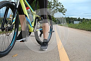Cropped image of sporty man riding a bicycle on country road. Travel, sport and active lifestyle concept