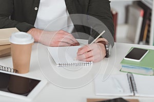 cropped image of student making notes