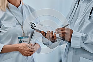 Cropped image of two doctors writing information on forms