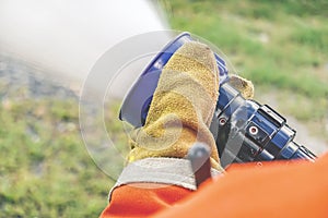 Cropped image of two pairs of hands holding the handle on the end of a firefighter`s water