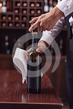 Cropped image waiter opening wine bottle