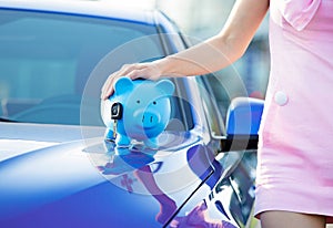 Cropped image woman customer, new car, piggy bank, key