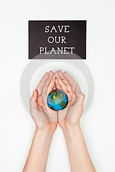 cropped image of woman holding earth model in hands under sign save our planet