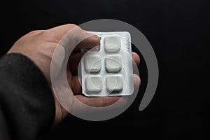 Cropped image of woman holding pile of blister packs with pills in hands