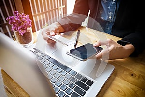 Cropped image of woman inputting card information and key on phone or laptop while shopping online