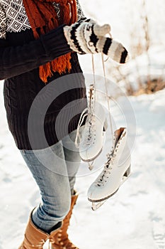 Cropped image of a woman with a pair of ice skates tied together