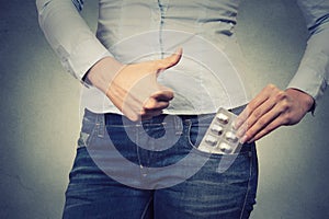 Cropped image of a woman with pills in her pocket showing thumbs up