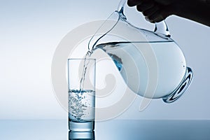 Cropped image of woman pouring water from jug