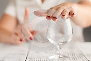 Cropped image of woman showing stop gesture and refusing to drink