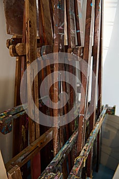 Cropped image of wooden easels smeared with oil paints in a art workshop. Painting tools. Fine art. Creative hobby