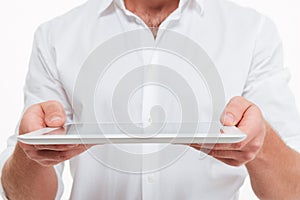 Cropped image of young man give you a tablet computer.