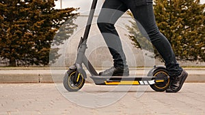 Cropped image of young man riding in the street on electric kick scooter