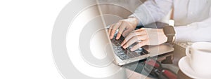 Cropped image of a young man working on his laptop, man hands busy using laptop at office desk. Young businessman working with