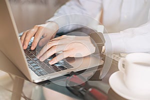 Cropped image of a young man working on his laptop, man hands busy using laptop at office desk, young male student typing on