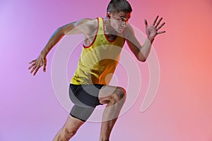 Cropped image of young professional male athlete isolated over gradient studio background. Marathon preparation
