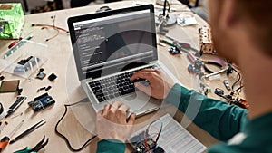 Cropped IT engineer programming code of microchip