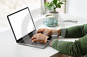 Cropped of man freelancer typing on laptop with white screen