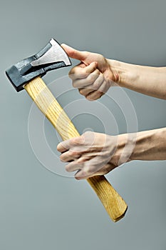 Cropped Man working in carpentry workshop, checking sharpness of ax blade