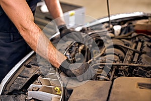 cropped mechanic in uniform is working in auto service. Car repair and maintenance