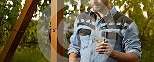 cropped oenologist man hold wine glass at winery outdoor, summer