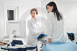 Cropped panorama of gynecologist examining a patient who is sitting in a gynecological chair. Female health concept.