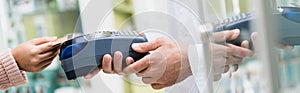 Cropped of pharmacist holding payment terminal