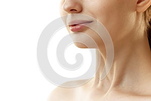 Cropped phot of young woman with well-kept, rejuvenated skin at on neckline zone against white studio background.