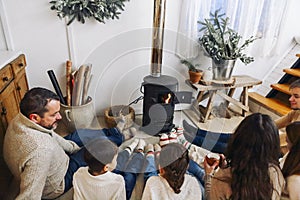 Cropped photo of big family wearing warm woolen socks resting by fireplace