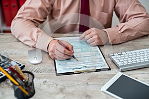 cropped photo of business man in jacket filling out tax forms and making calculations at desk.