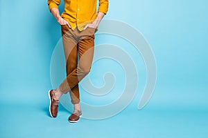 Cropped photo of confident man legs in footwear crossed with hands in pockets standing confidently  over pastel