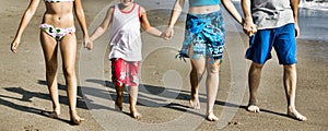 Cropped photo of family walking on the beach