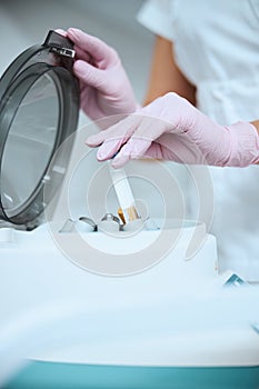 Cosmetologist using the laboratory equipment for a beauty procedure photo