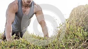 Cropped photo of a fit man doing pushups outdoors at a hill. Chest or full body workout. Calisthenics or High intensity training