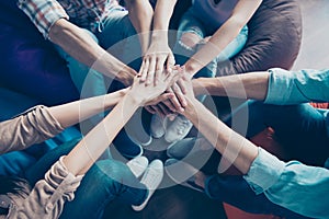 Cropped photo of friendly cheerful workers shacking arms together teambuilding lesson indoors workplace workshop