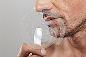 Cropped photo of of handsome mature man holding lip balm.