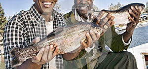 Cropped photo of happy father and son showing freshly caught fish