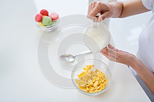 Cropped photo of housewife hands holding pouring milk jug cooking breakfast cornflakes healthy eating concept keeping to