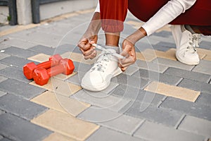 Cropped photo of legs of sporty woman who tie her shoelaces