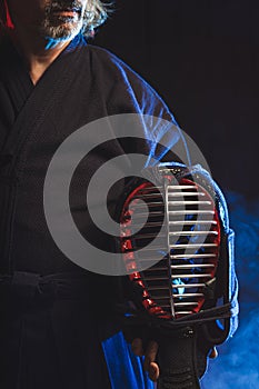 Cropped photo of man holding kendo helmet